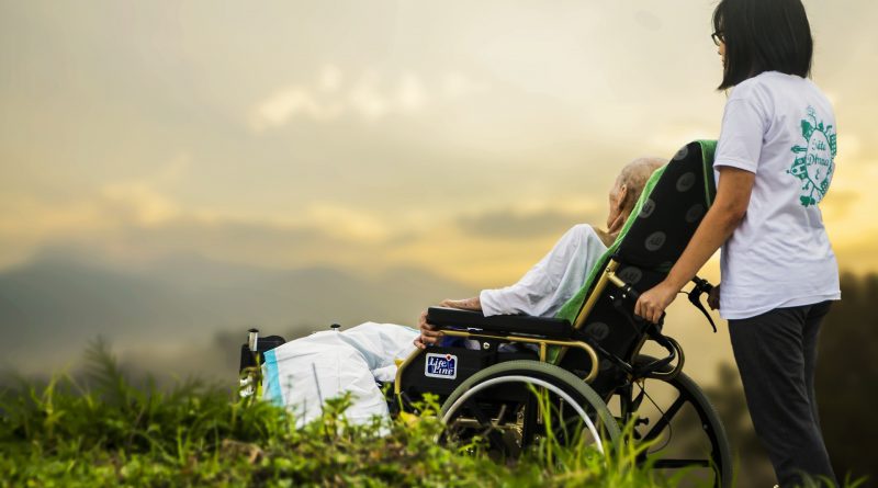 Altenpflegerin mit Rollstuhl